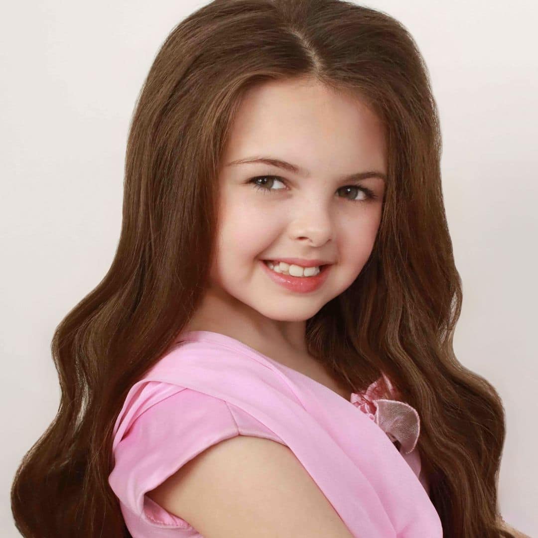 Smiling girl with long brown hair.