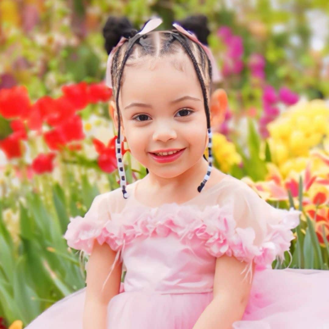 Smiling girl in pink dress with colorful flowers