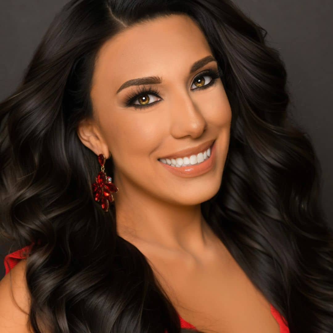 Smiling woman with long dark hair and red earrings