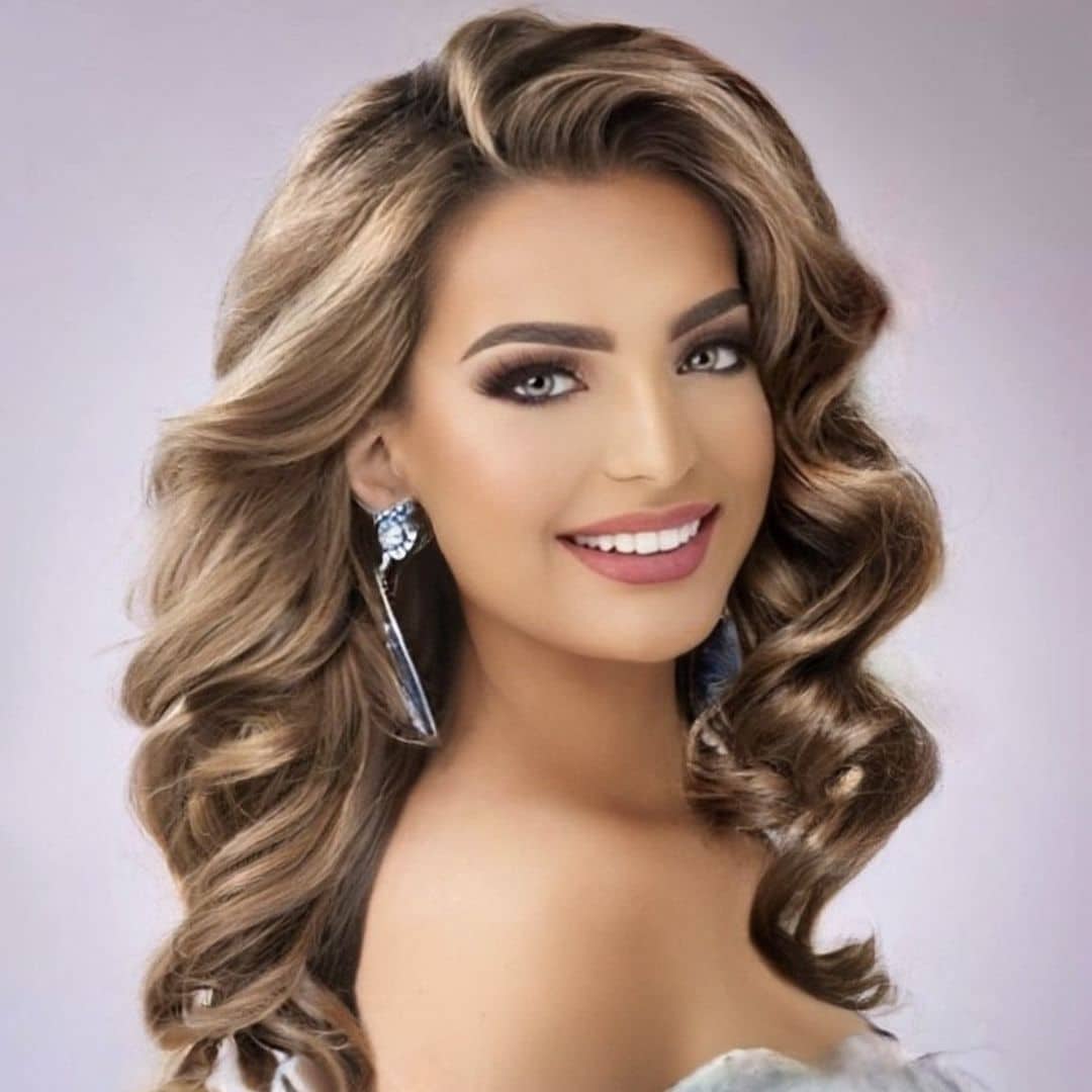 Smiling woman with curly hair and earrings