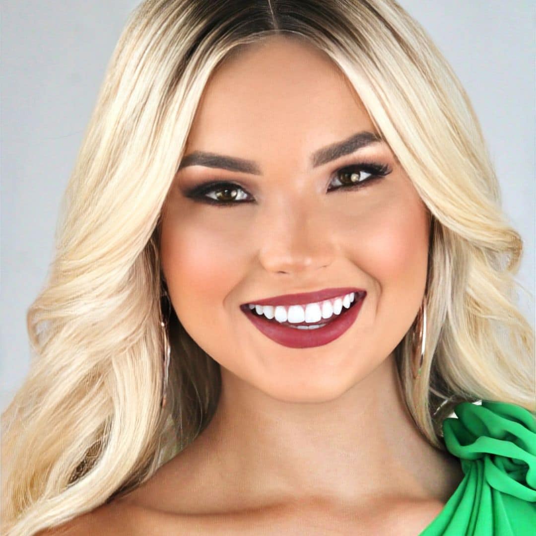 Smiling woman with blonde hair in green dress