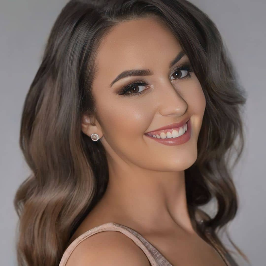 Smiling woman with wavy hair and earrings