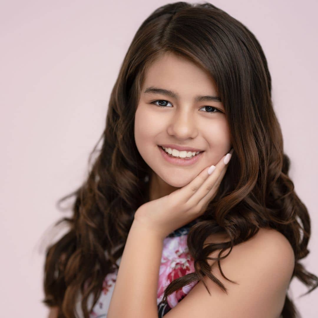 Smiling girl with brown hair and floral dress