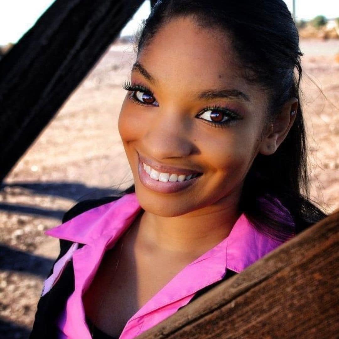 Smiling woman in pink shirt, outdoor setting