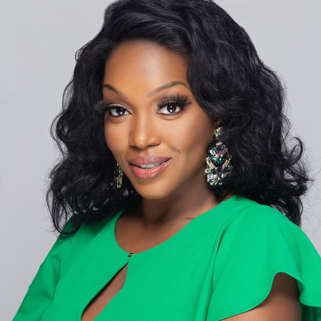 Woman in green dress with colorful earrings smiling