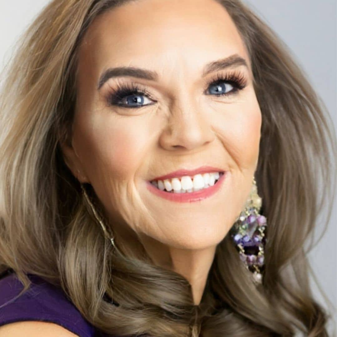 Smiling woman with long hair and earrings.