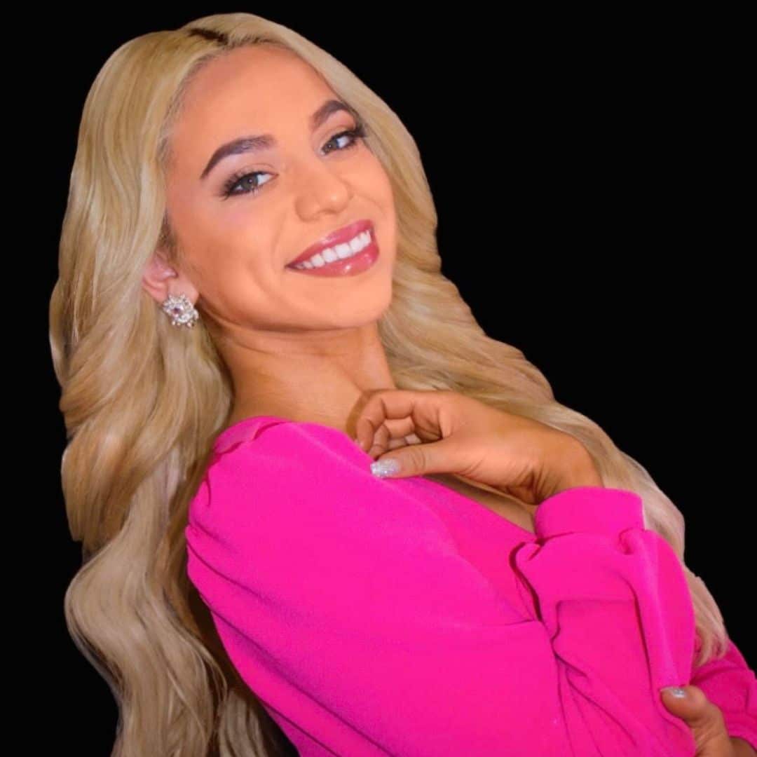 Smiling woman with blonde hair in pink outfit.