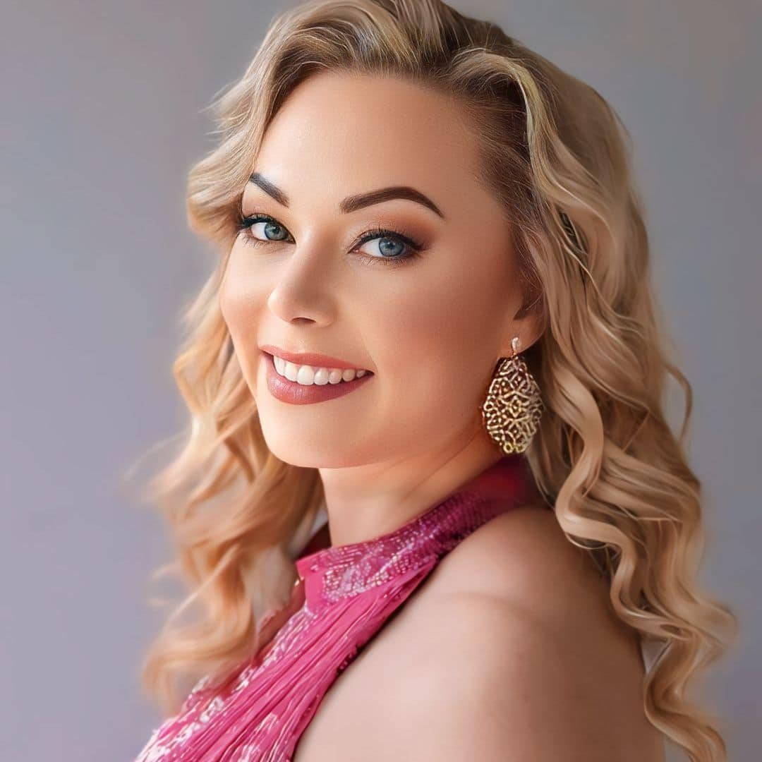 Smiling woman with blonde hair in pink dress