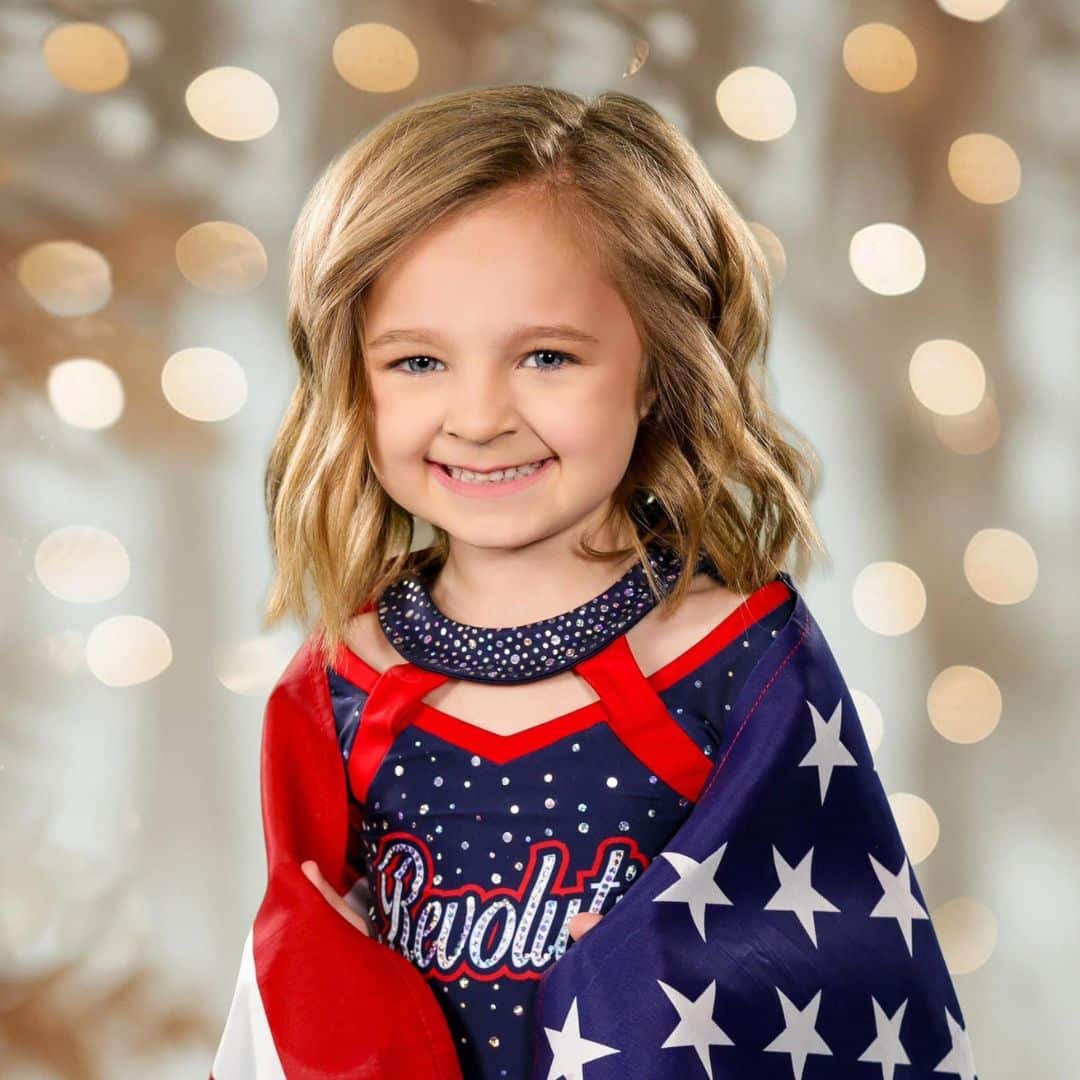 Smiling girl with American flag backdrop