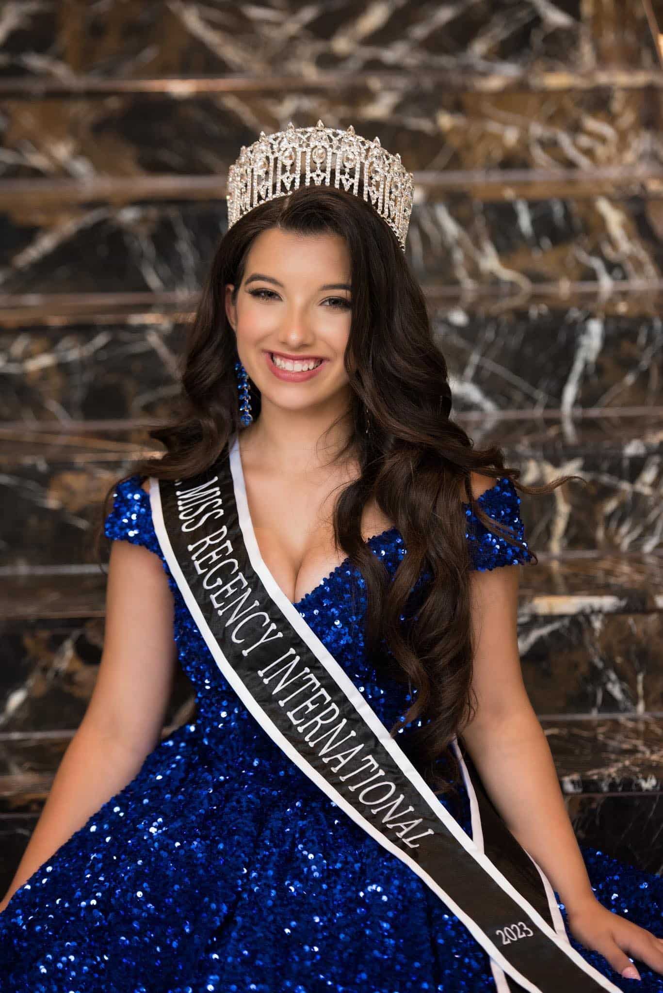 Pageant winner in blue sequin dress with crown.