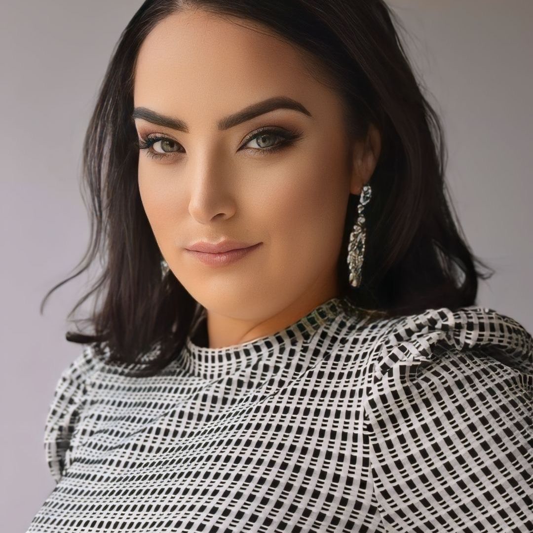 Woman with makeup wearing patterned top.