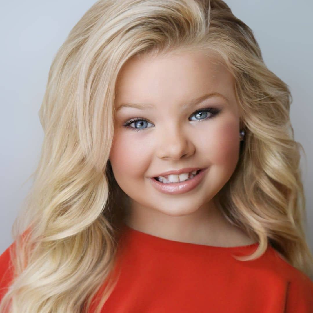 Smiling girl with blonde hair in red dress