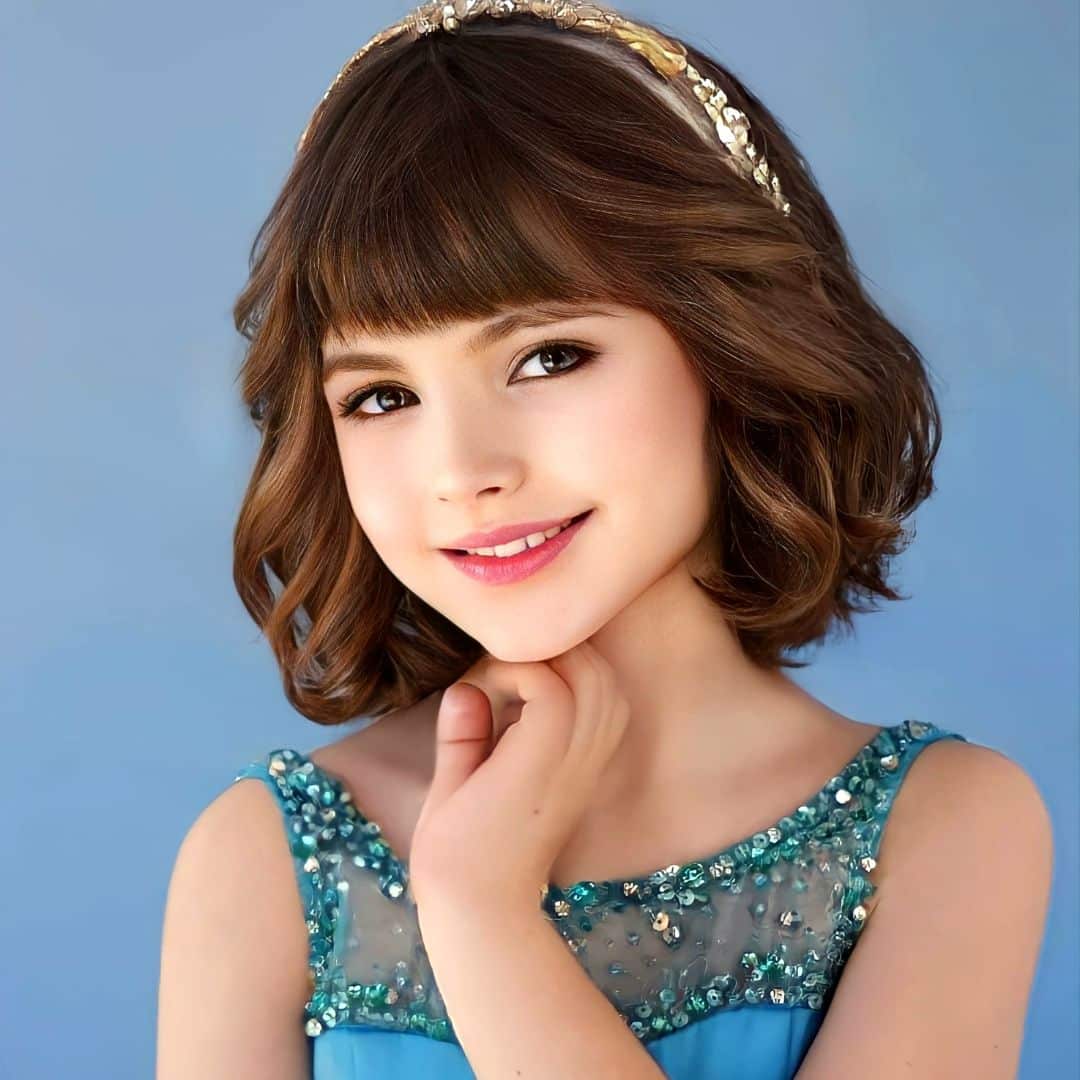 Smiling girl in blue dress with headband.