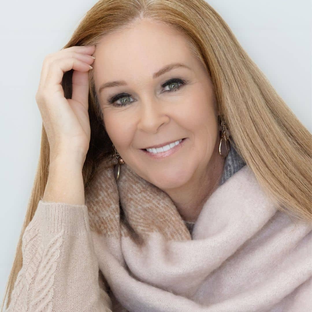 Smiling woman in beige sweater and scarf