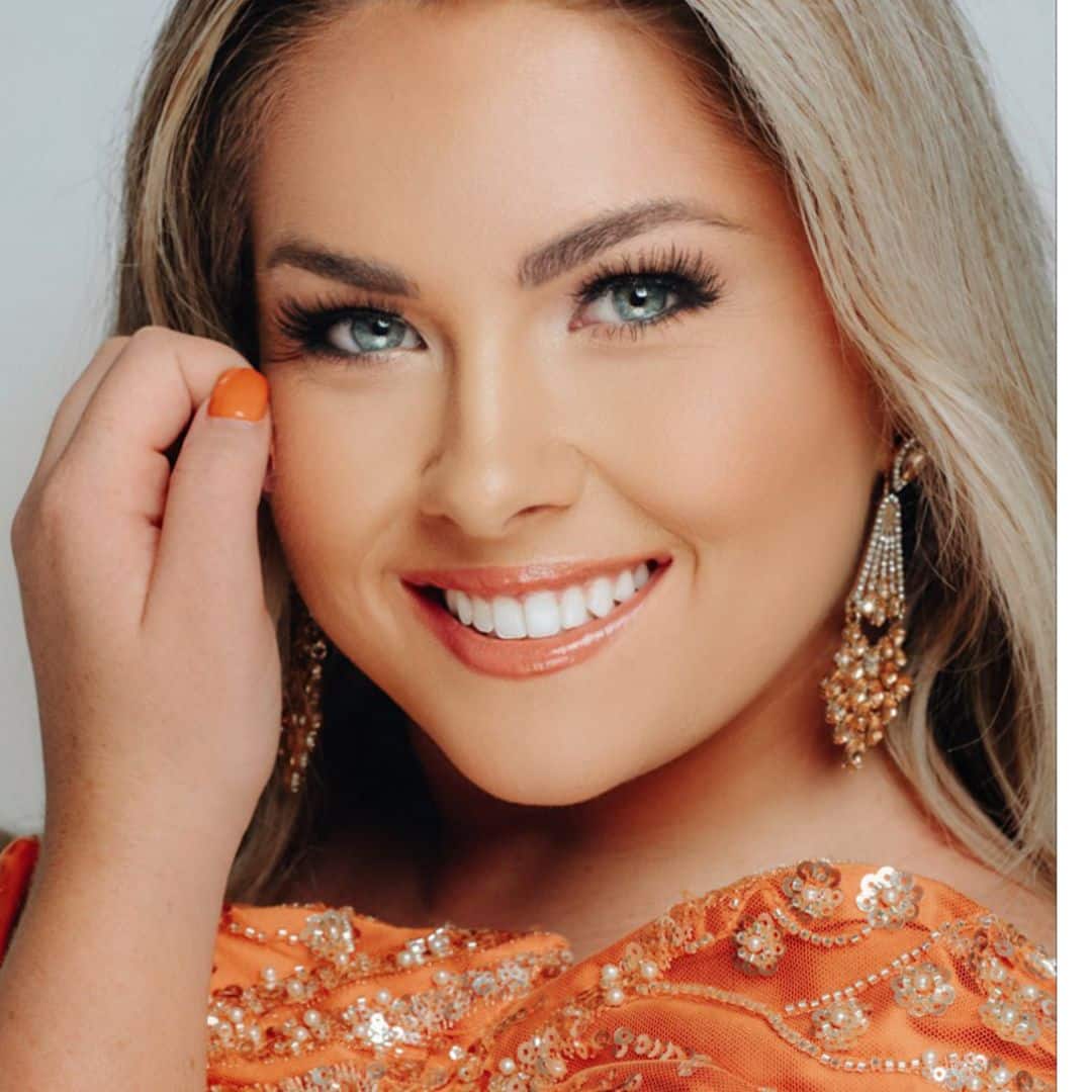 Smiling woman in orange dress and earrings