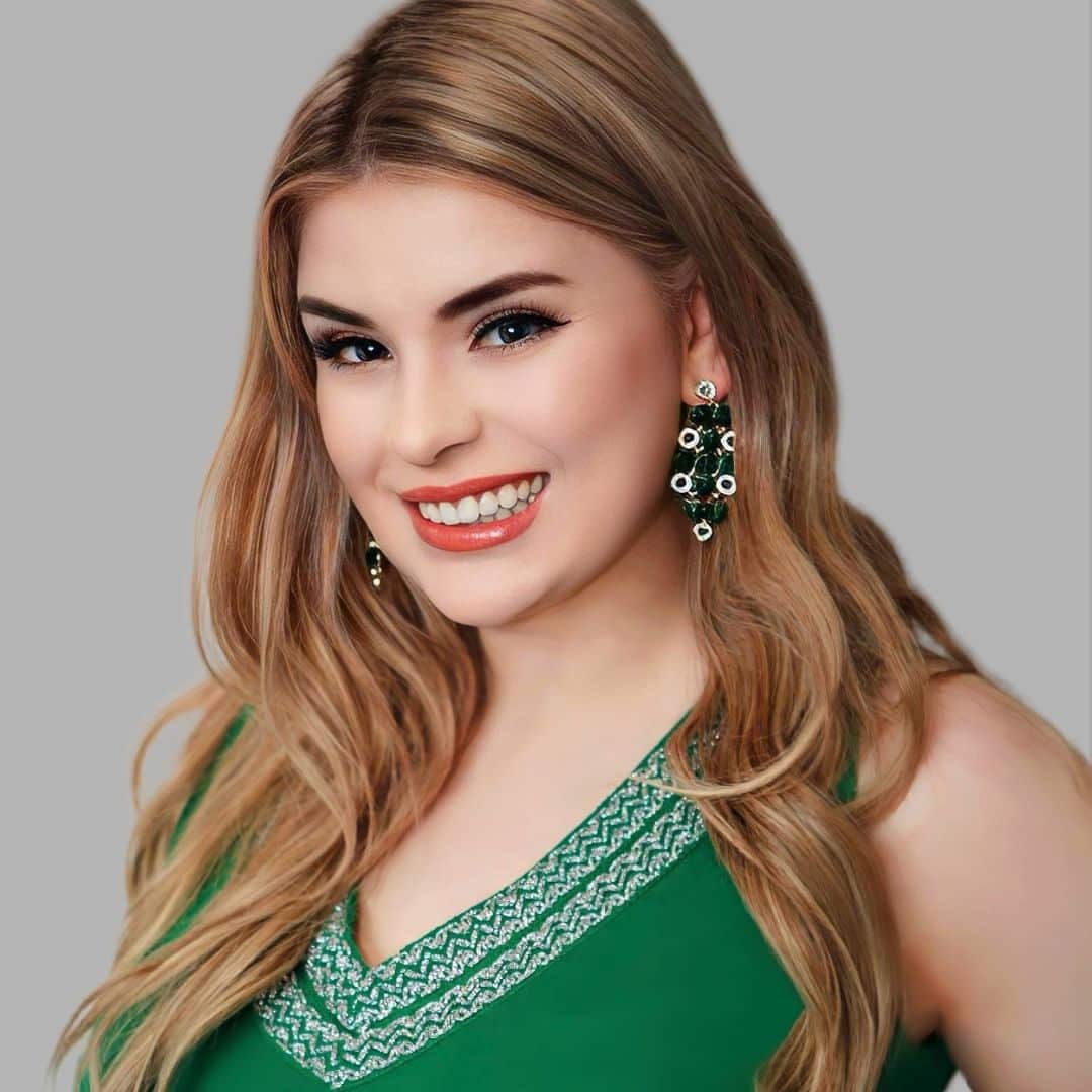 Smiling woman in green dress with earrings