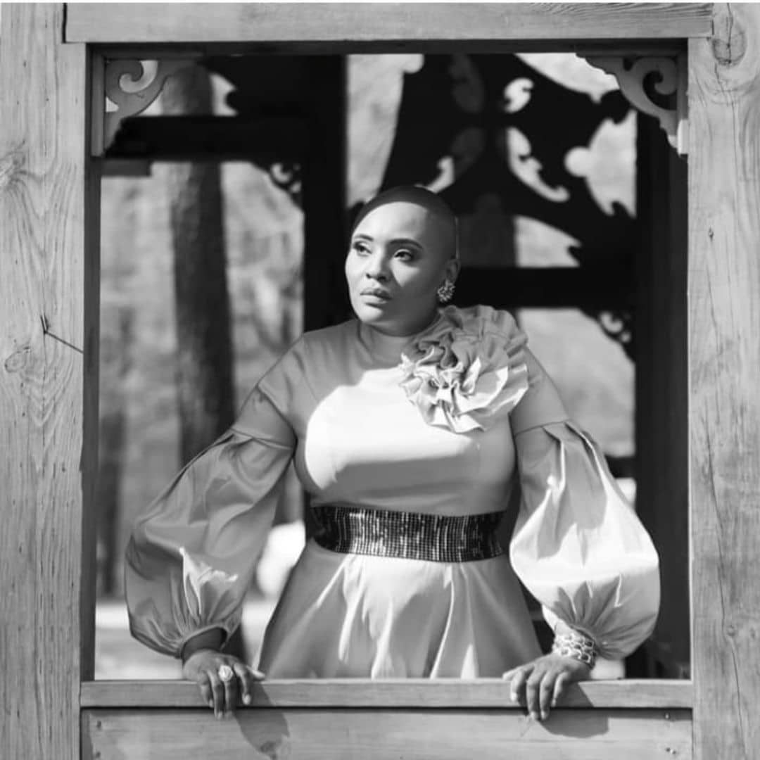 Woman in elegant dress stares thoughtfully.