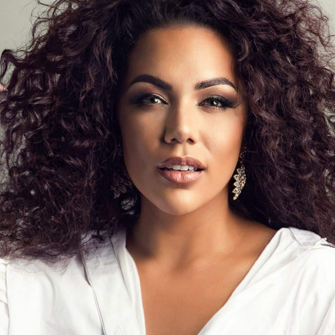 Woman with curly hair and white top.