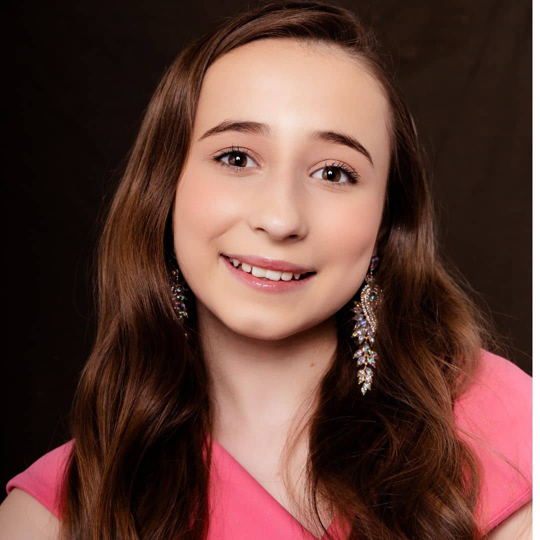 Smiling girl in pink dress.