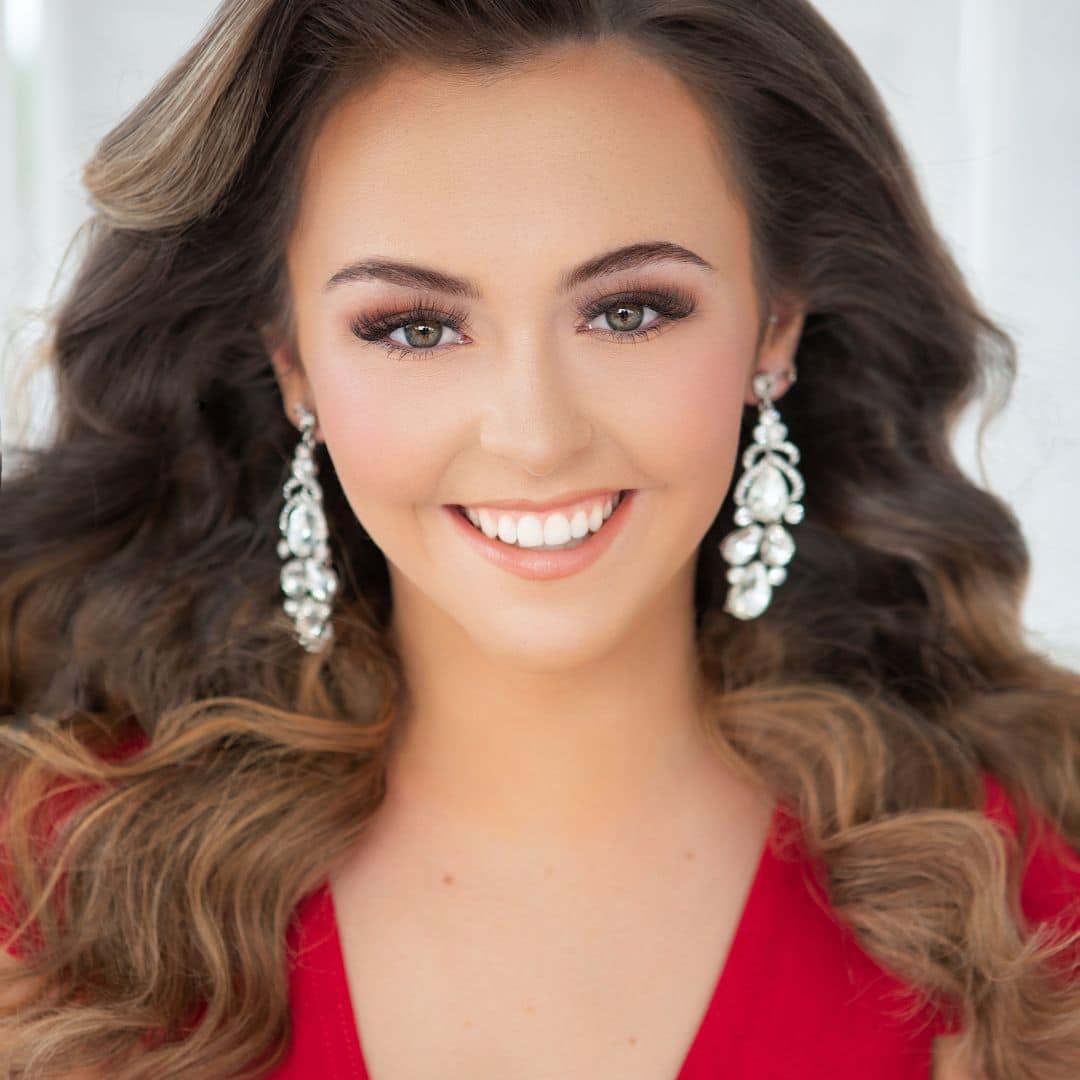 Smiling woman wearing long earrings, curly hair