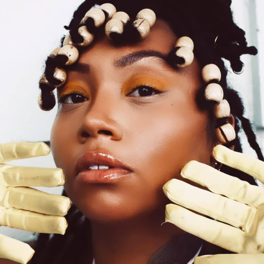 Woman with bead hairstyle and yellow gloves