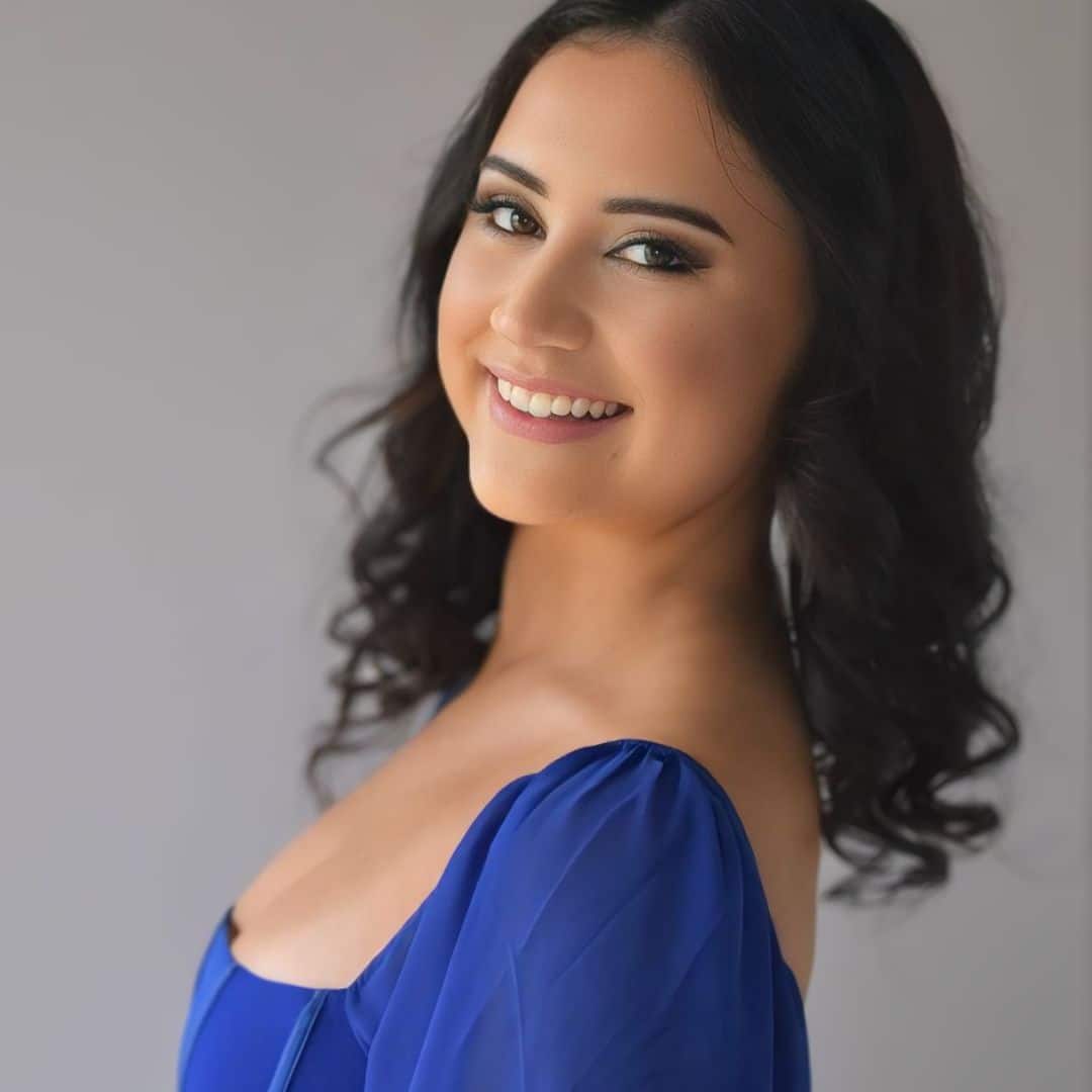 Smiling woman in blue dress.