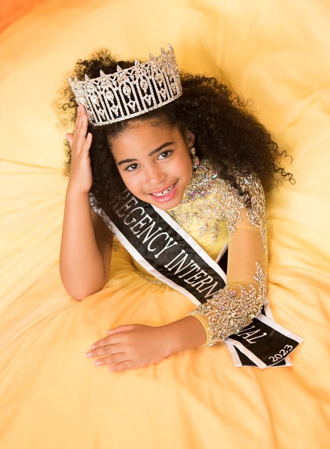 Young girl in crown and sash, pageant winner.